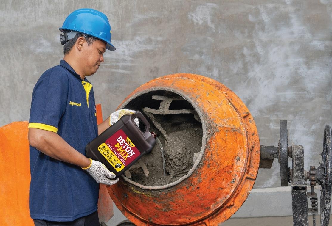 A person pouring cement into a cement mixerDescription automatically generated